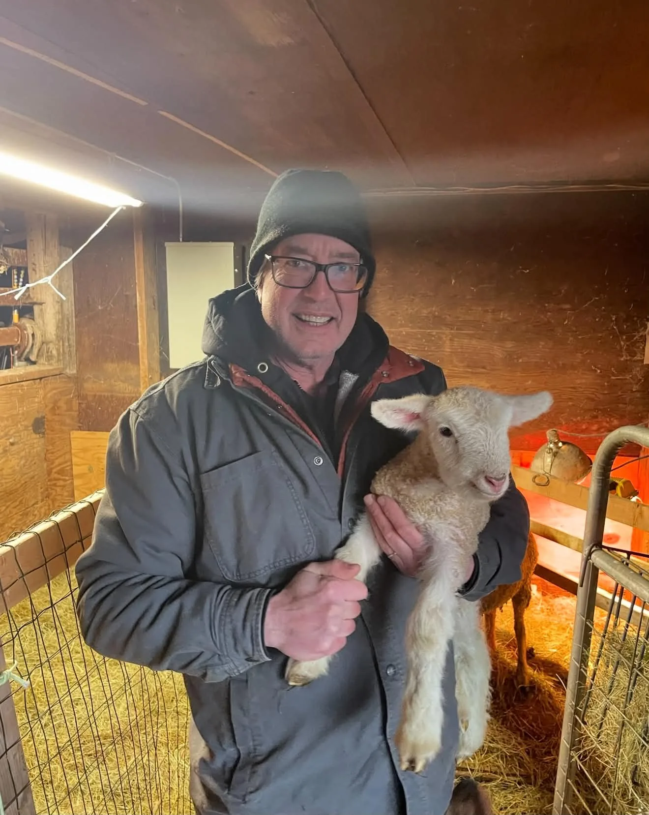 Family member holding a lamb at Round Valley Farms
