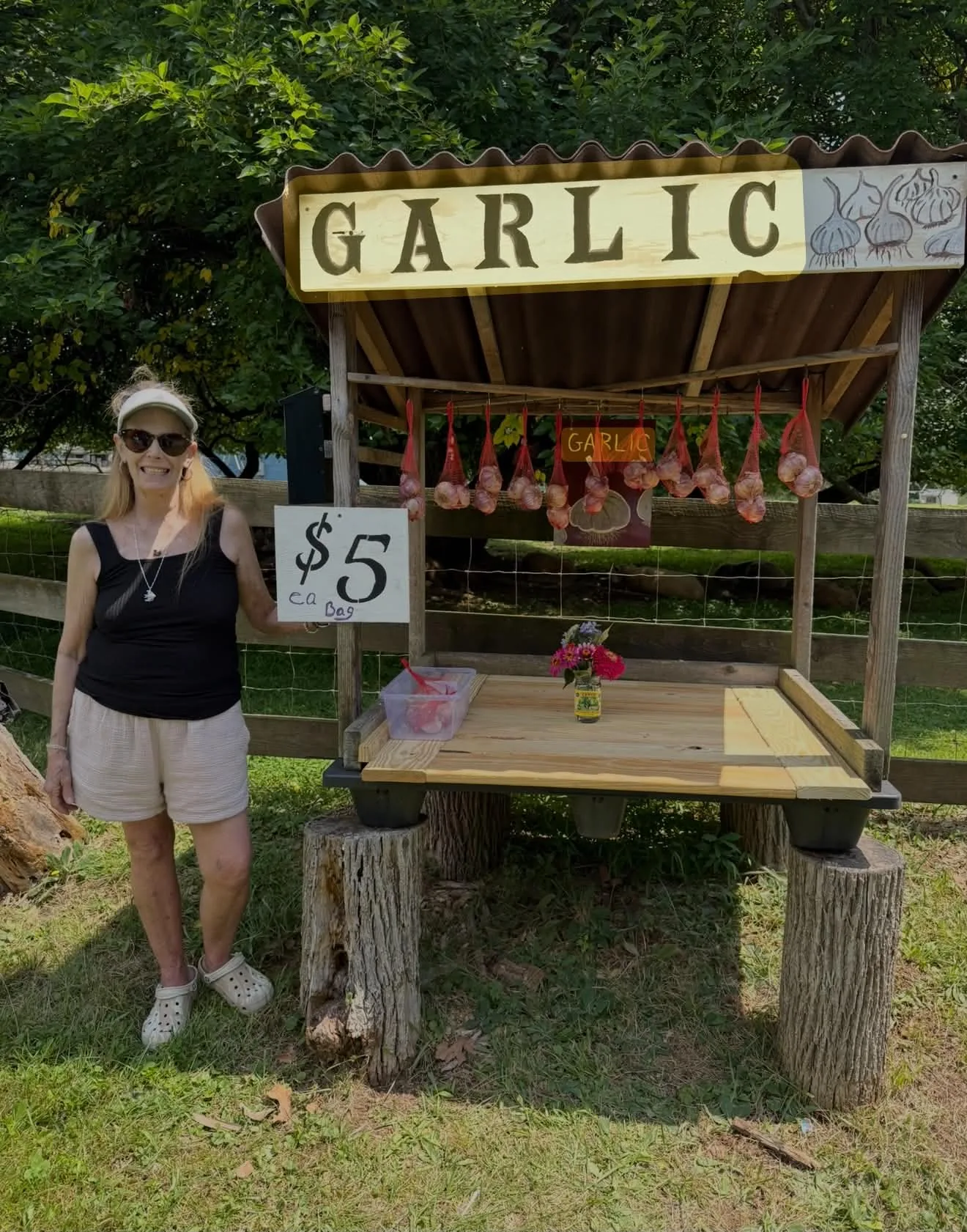 Family member beside the farm garlic stand